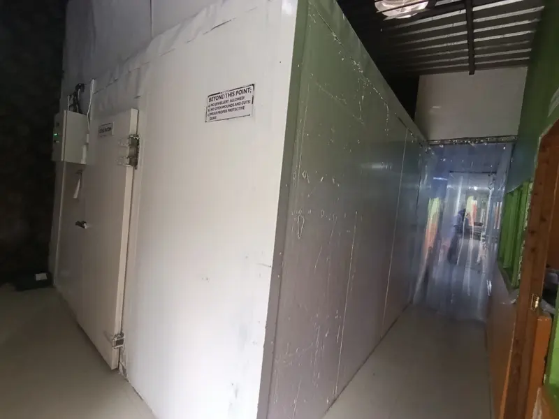 Walk-in cold room door with food-safety signage and wall-mounted controls