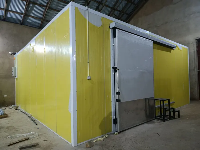 Yellow insulated-panel coldroom with a diamond-plate sliding door